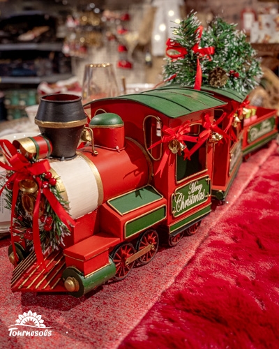 Train miniature festif rouge et vert orné de décorations de Noël.